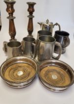 A group of silver plated items, including tankards, a bottle coaster, candlesticks, a coffee pot,