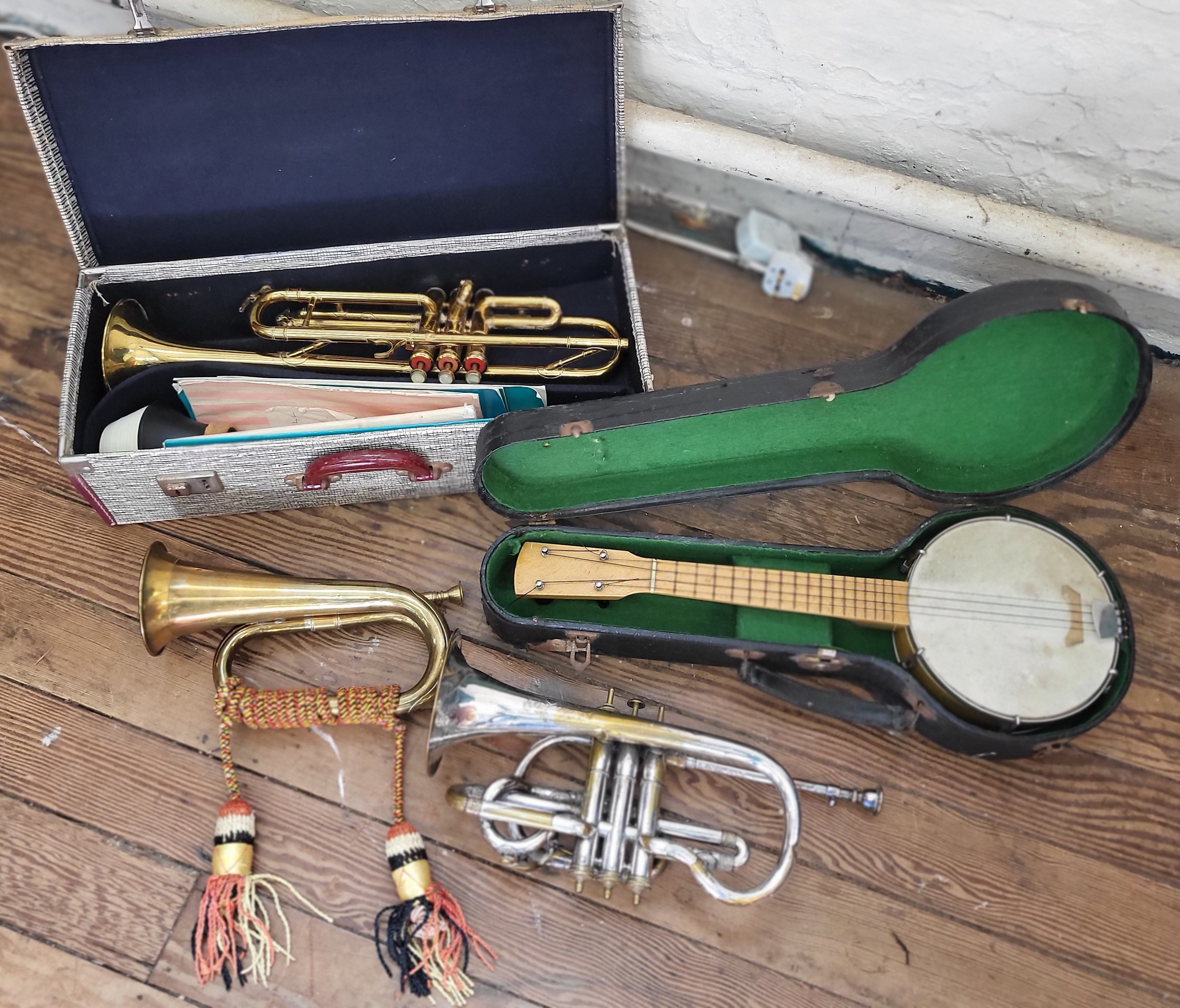 A bugle, together with two trumpets (one of which is a Boosey & Hawkes), and a banjo-ukulele. (4)