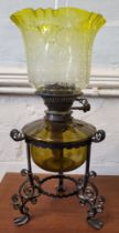 An oil lamp with yellow glass shade.