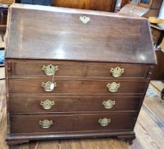 A George III mahogany bureau, having two short and three long drawers, brass handles, supported on