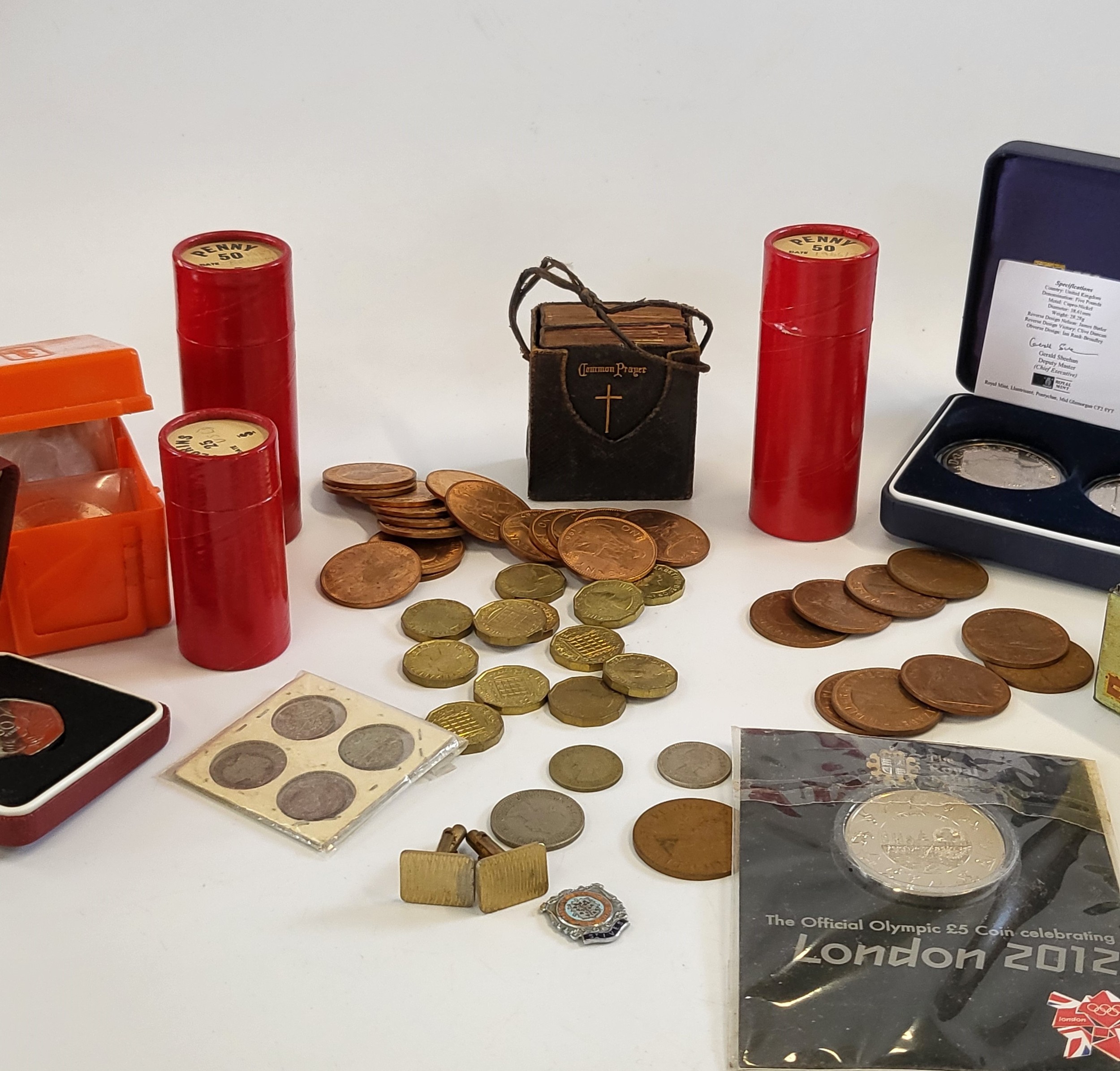 A collection of coins and loose stamps and an album of stamps.
