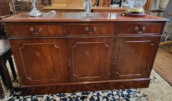 A large mahogany sideboard with three drawers over three cupboards. 79cm x 140cm x 40cm.