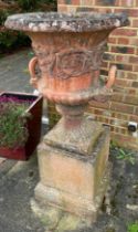 A pair of large red stone campagna shaped urns (80cm x 66cm), with everted rims and twin handles,