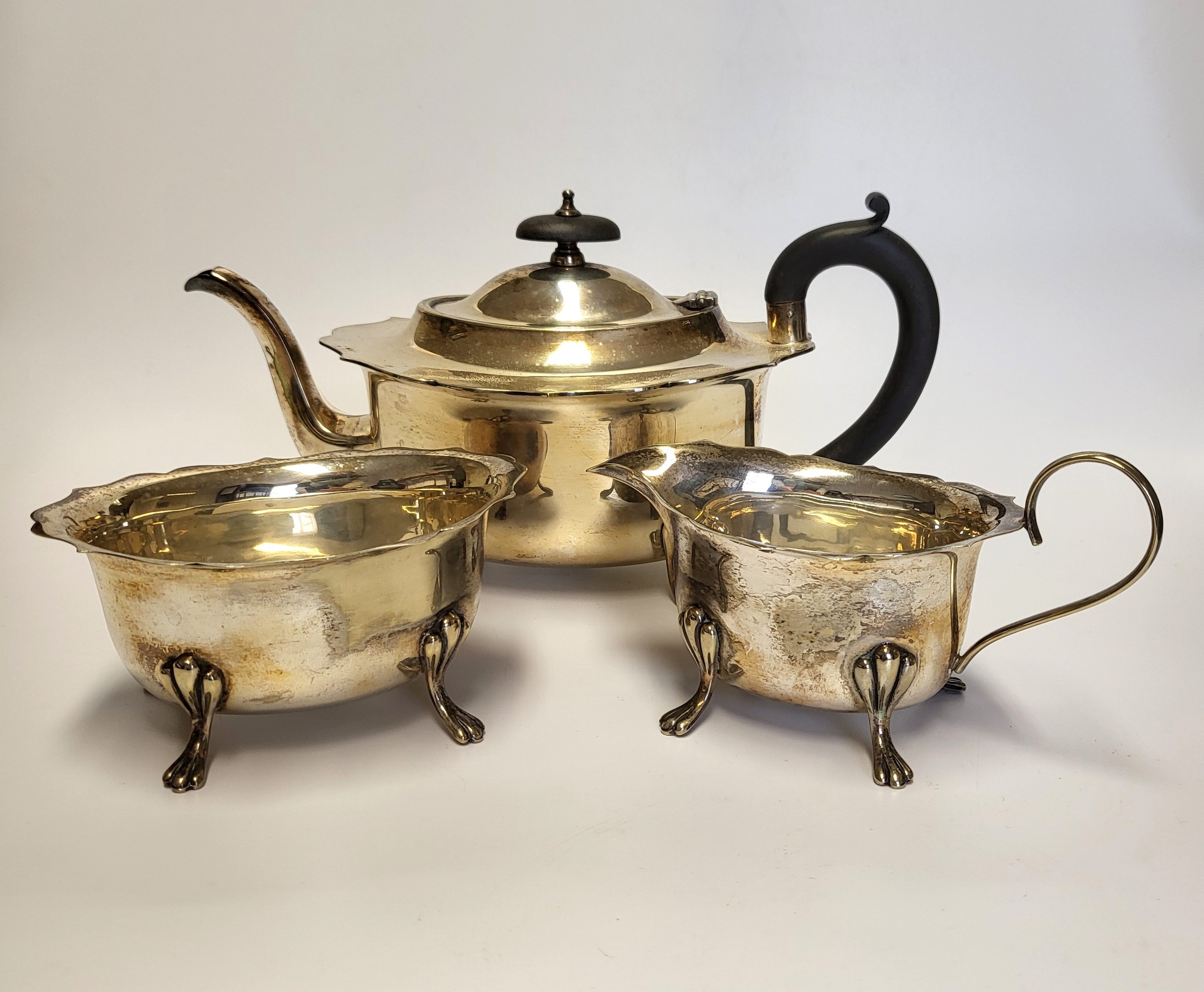 A silver plated tea set, comprising of teapot, milk jug, and sugar bowl, with shaped rim, raised