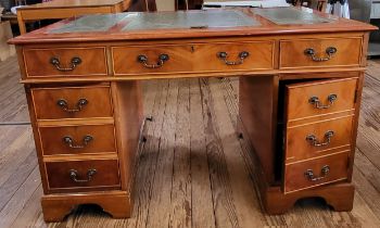 A wooden pedestal desk, with green leather top, in three parts. Left cabinet has three drawers,