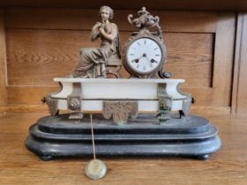 An ornate mantle clock, the white dial beside the seated figure of a Classical woman, raised on