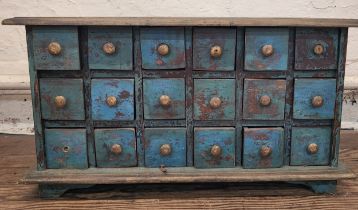 A 20th century wooden apothecary unit, fitted with eighteen square drawers, painted blue,
