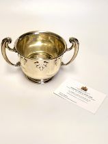 A silver twin handled porringer cup, the cup with foliate decoration, hallmarked London 1917, makers