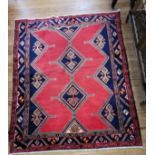 An Afshar blue and red ground Persian rug, with diamond medallion design. 190cm x 155cm.