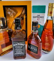 A group of bottles of whisky, Cognac, and liqueur, including Glenmorangie Highland single malt