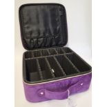 A purple fabric travelling jewellery case, with zips and handle, square.