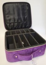 A purple fabric travelling jewellery case, with zips and handle, square.