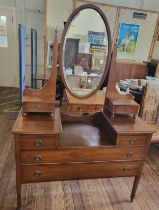 A mahogany dressing table with an oval mirror and a drawer either side, and two short drawers over