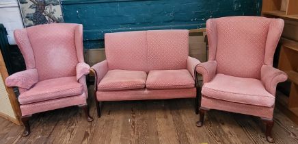 A pink Parker Knoll upholstered sofa (87cm x 120cm x 64cm) and a pair of wingback chairs (96cm x