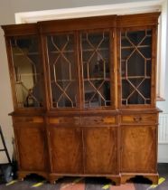 A break front bookcase cabinet with four mullioned glass doors over four drawers and four lockable