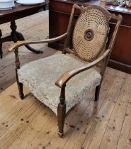 An Edwardian Beech Bergere armchair with oval caned back and central carved medallion 86cm x 61cm