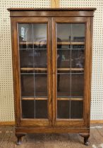 An oak leaded glass front bookcase, lockable with key 128cm x 76cm x 28cm.