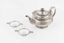 A William IV silver teapot, with lobed and gadrooned decoration, and foliate capped reeded handle,