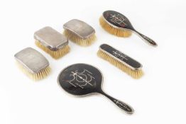 A George V silver mounted tortoiseshell backed dressing table set, comprising hand mirror, hair