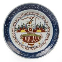 An 18th century Dutch Delft polychrome dish with a vase of flowers circa 1735, 35,5cm diameter