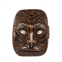 A 20th century Papua New Guinea carved hardwood mask with cowrie shell eyes. 45cm x 59cm.