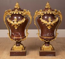 A pair of French Empire style rouge marble lidded urns