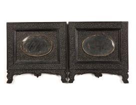 A pair of 19th century Indian carved ebony picture frames each with oval bevelled glass 25cm x 24cm