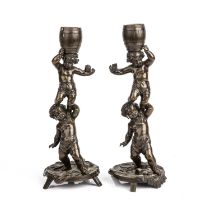 A pair of late 19th century French bronze cherub candlesticks signed H Perrot. 10cm wide 25.5cm high