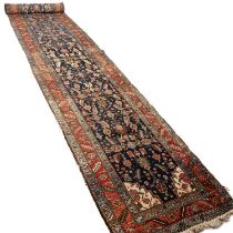 An antique Persian Heriz country house runner labelled Harvey Nicholls 98cm x 565cm Appears to be in