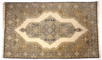A middle Eastern Qum yellow and blue ground rug with a central motif and geometric decoration, 134cm