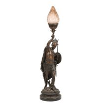 An antique patinated spelter lamp in the form of an American Indian holding a bow, having a frosted