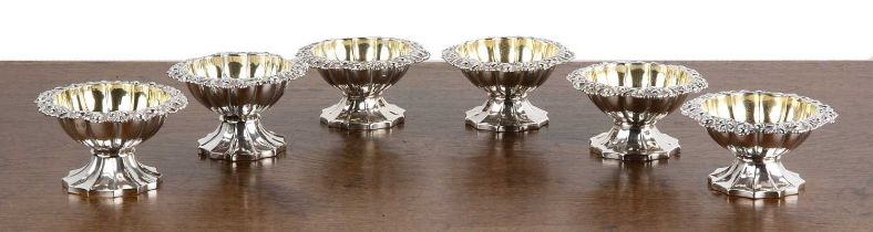 Matched set of six Georgian silver salts of shaped pedestal form, with shell and foliate scrolls