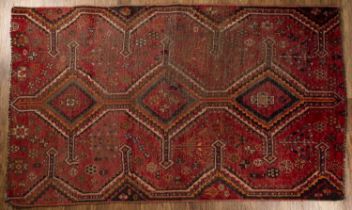 Red ground rug fragment of geometric design, 200cm x 115cm Worn.