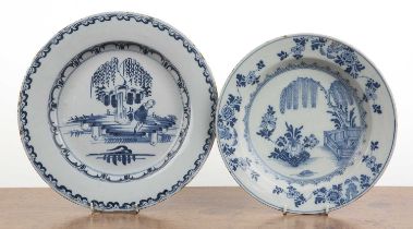 Two Delft tin glazed plates the larger example decorated with a Asian figure in a landscape with