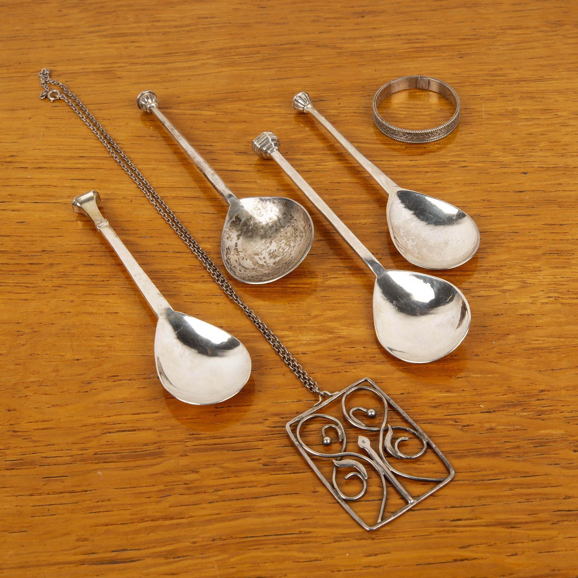 Group of silver comprising: four Guild of Handicraft seal topped silver spoons, bearing marks for