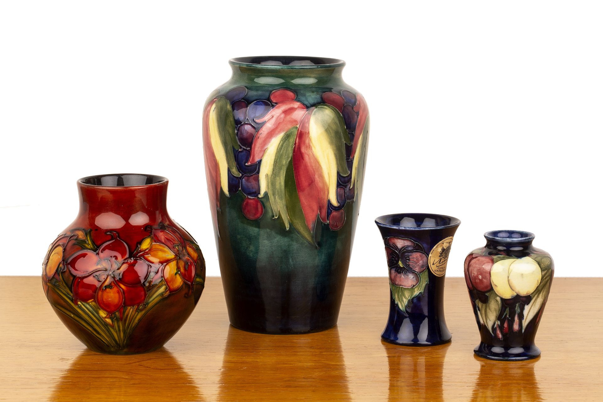 Collection of Moorcroft vases comprising a large 'leaf and berry' tapering vase on blue ground,
