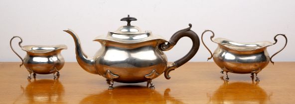 Three piece silver tea set comprising a teapot, twin handled sucrier and milk jug, all standing on