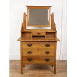 In the manner of Liberty & Co oak, dressing table, the top fitted with a rectangular bevelled edge
