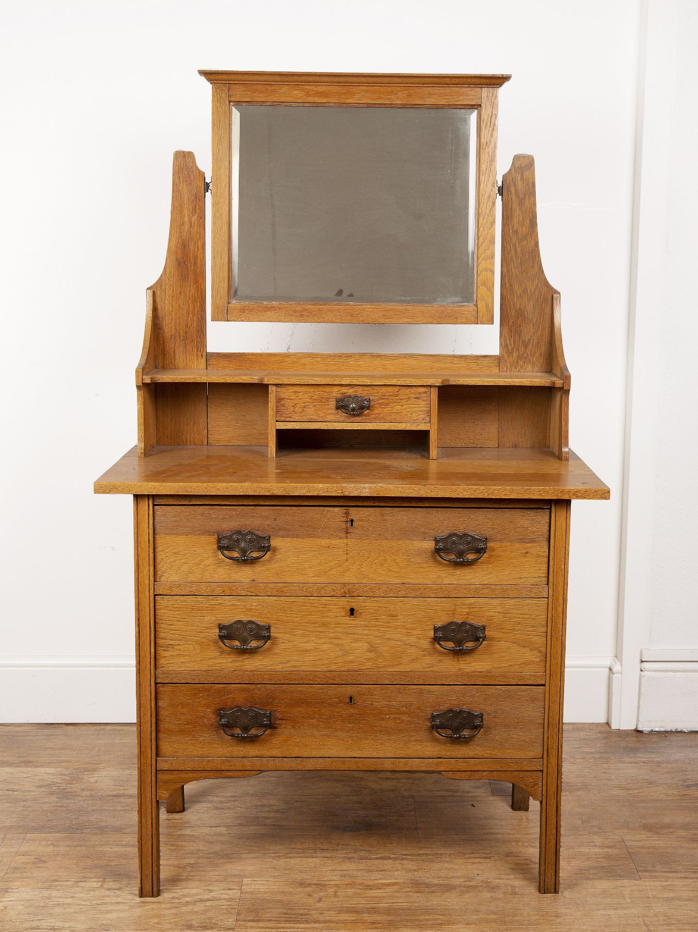 In the manner of Liberty & Co oak, dressing table, the top fitted with a rectangular bevelled edge