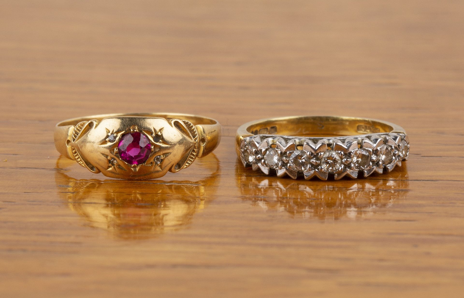 Two 18ct gold rings the first set with seven diamonds, size P, the other set with a facet cut