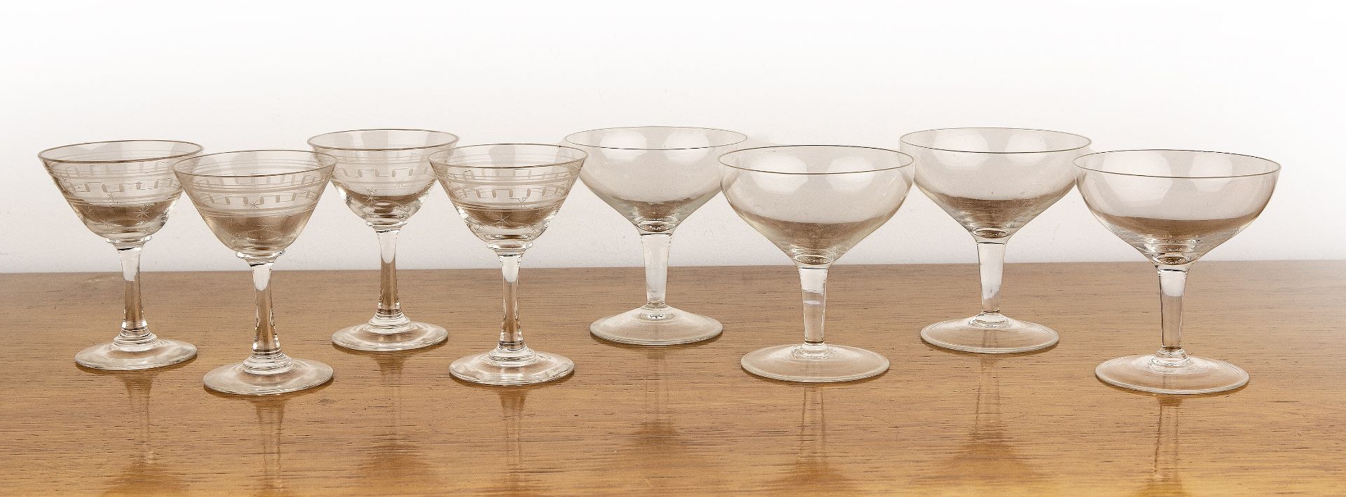 Collection of vintage glassware consisting of four etched glass cocktail glasses with Greek key