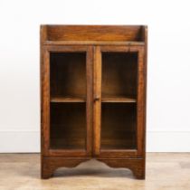 Attributed to Heals oak cupboard, with galleried top, two glazed panel doors with a turned wooden