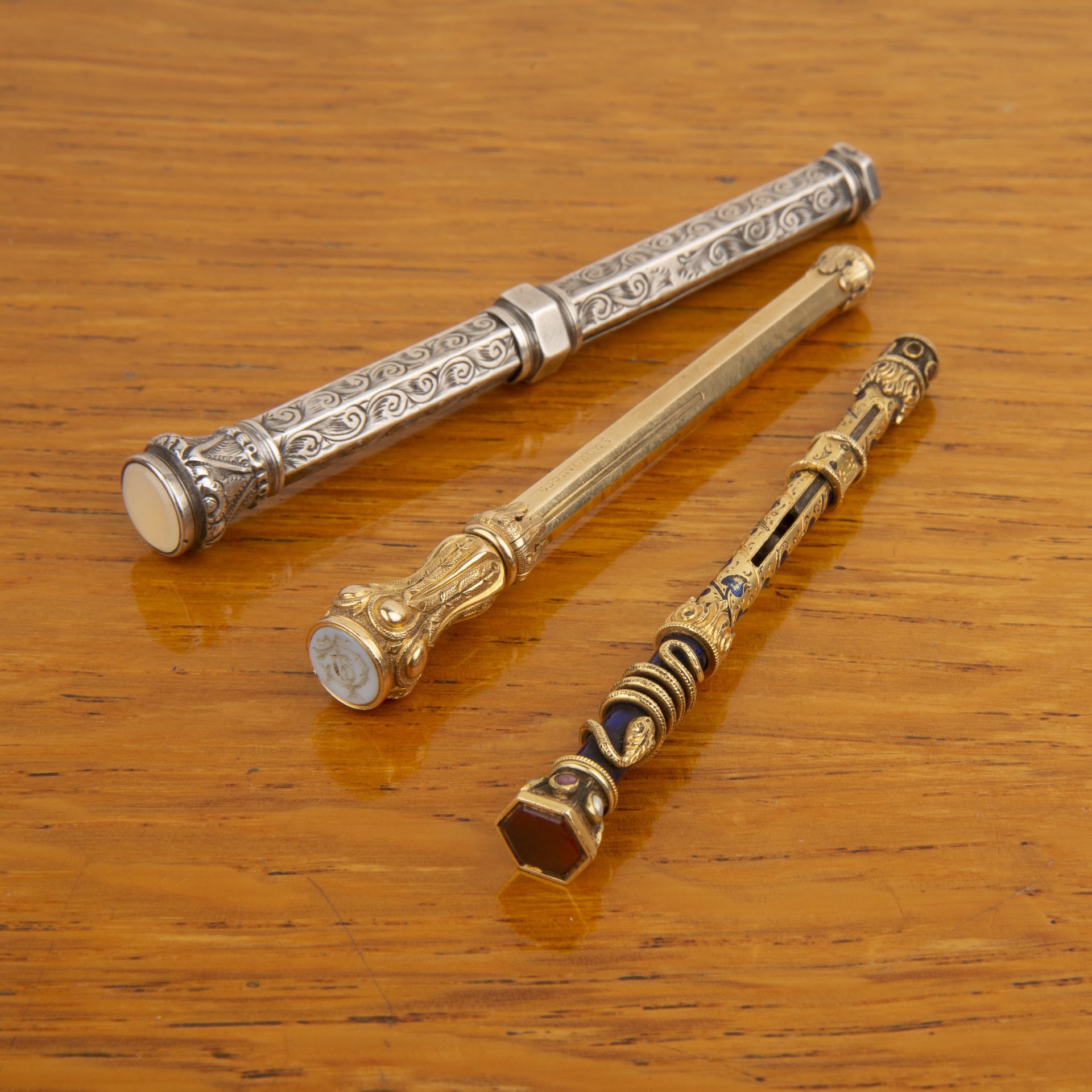 Three propelling pencils one a gilt metal example by Sampson Mordan & Co, with carved intaglio to