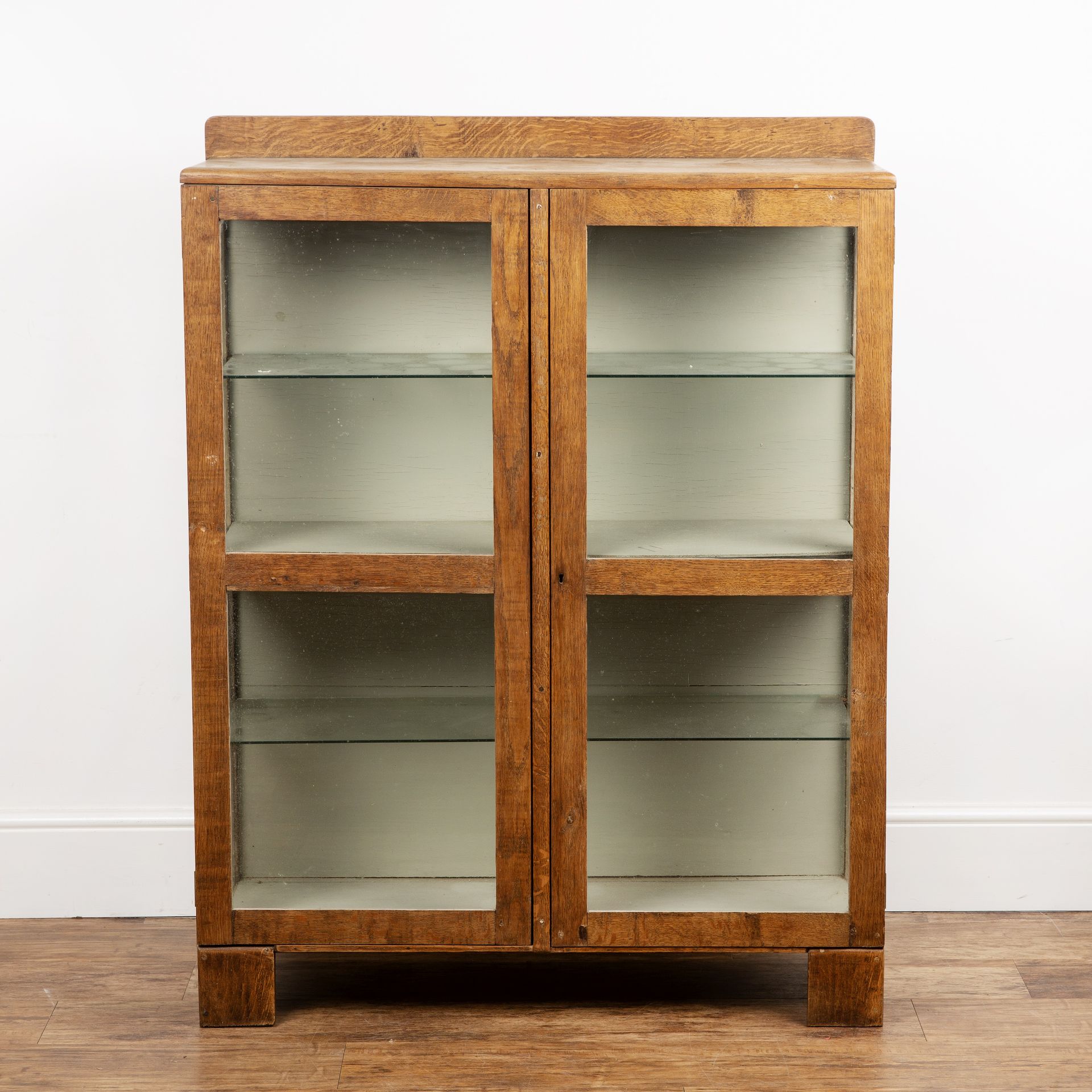 Cotswold School oak, glazed bookcase or cabinet, with galleried back above panelled doors, 95cm wide