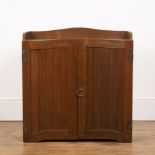 Cotswold School oak, panelled cupboard, with brass ring handle, decorative hinges and a fitted