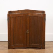 Cotswold School oak, panelled cupboard, with brass ring handle, decorative hinges and a fitted