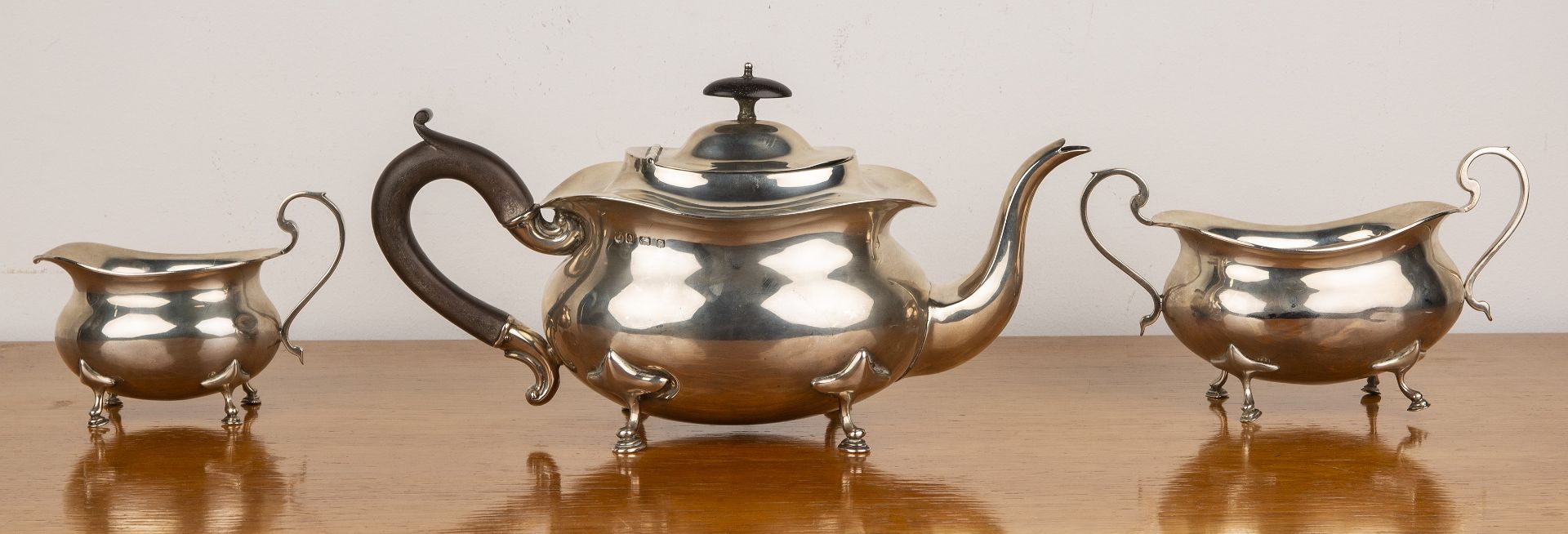 Three piece silver tea set comprising a teapot, twin handled sucrier and milk jug, all standing on - Image 2 of 5