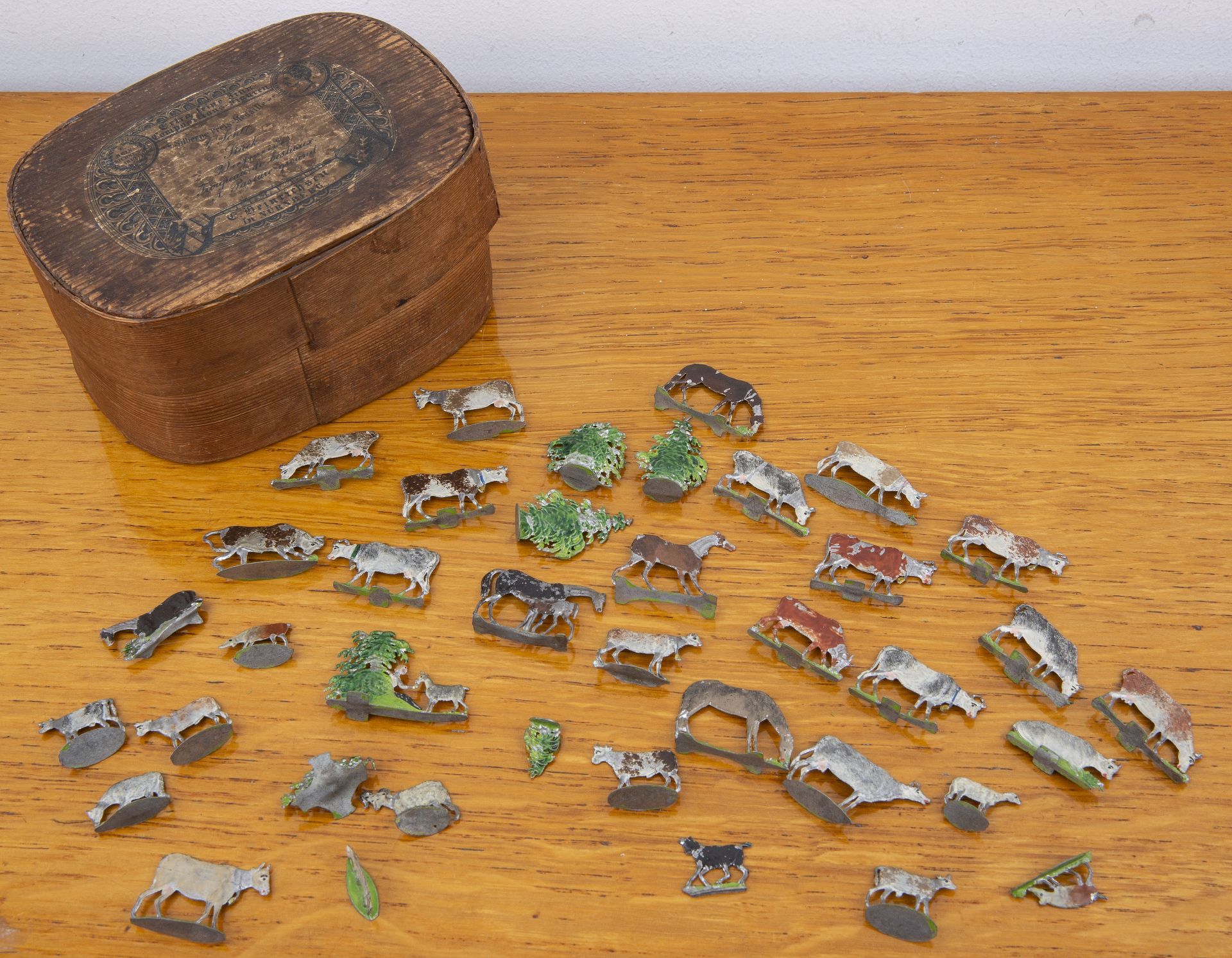 Collection of lead painted cows and related civilian figures, in original wooden box with paper
