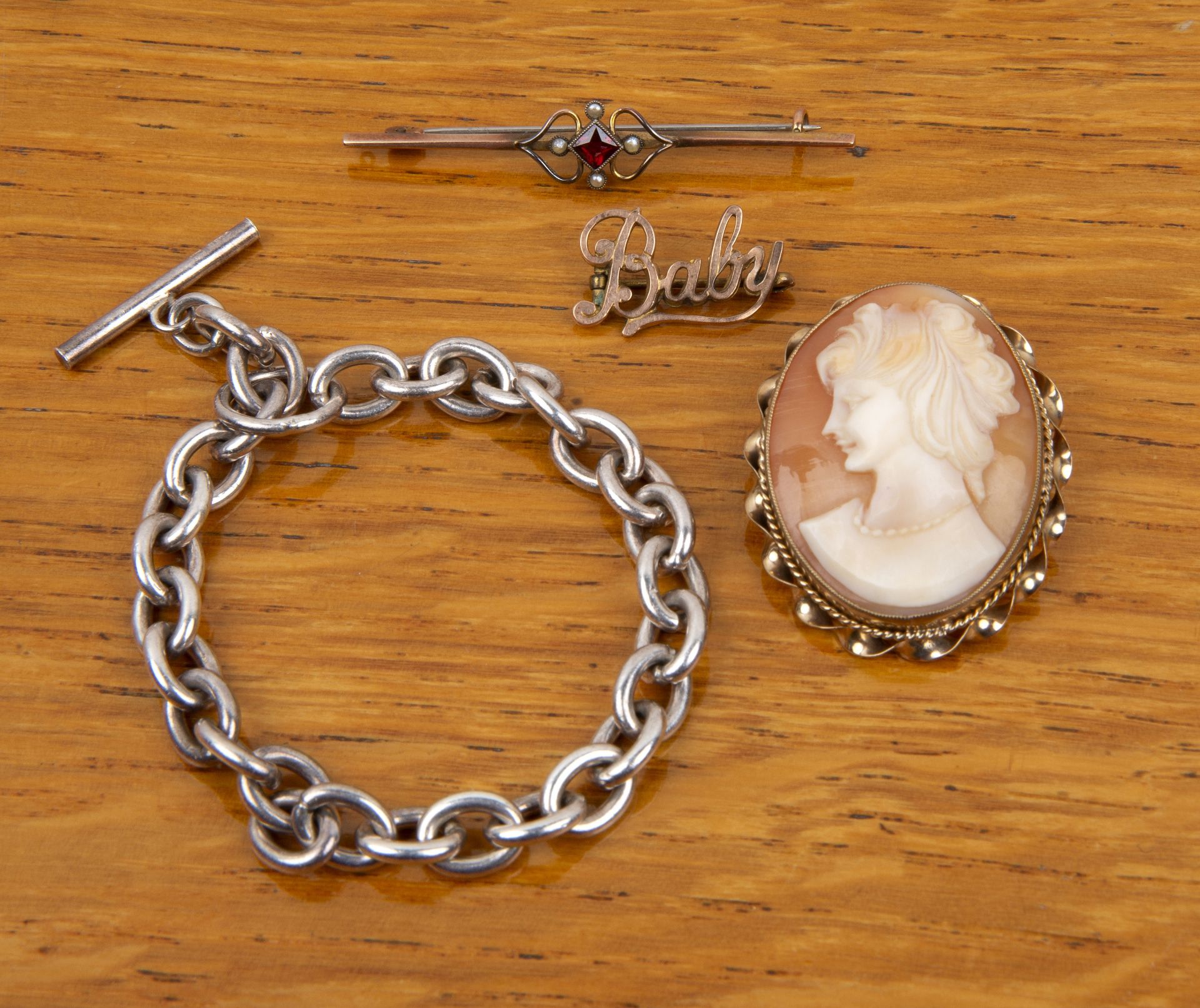 Group of jewellery to include: a silver t-bar chain link bracelet, a 9ct gold bar brooch set with