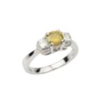 A diamond three stone ring, with central brilliant cut fancy intense yellow stone of 0.68ct